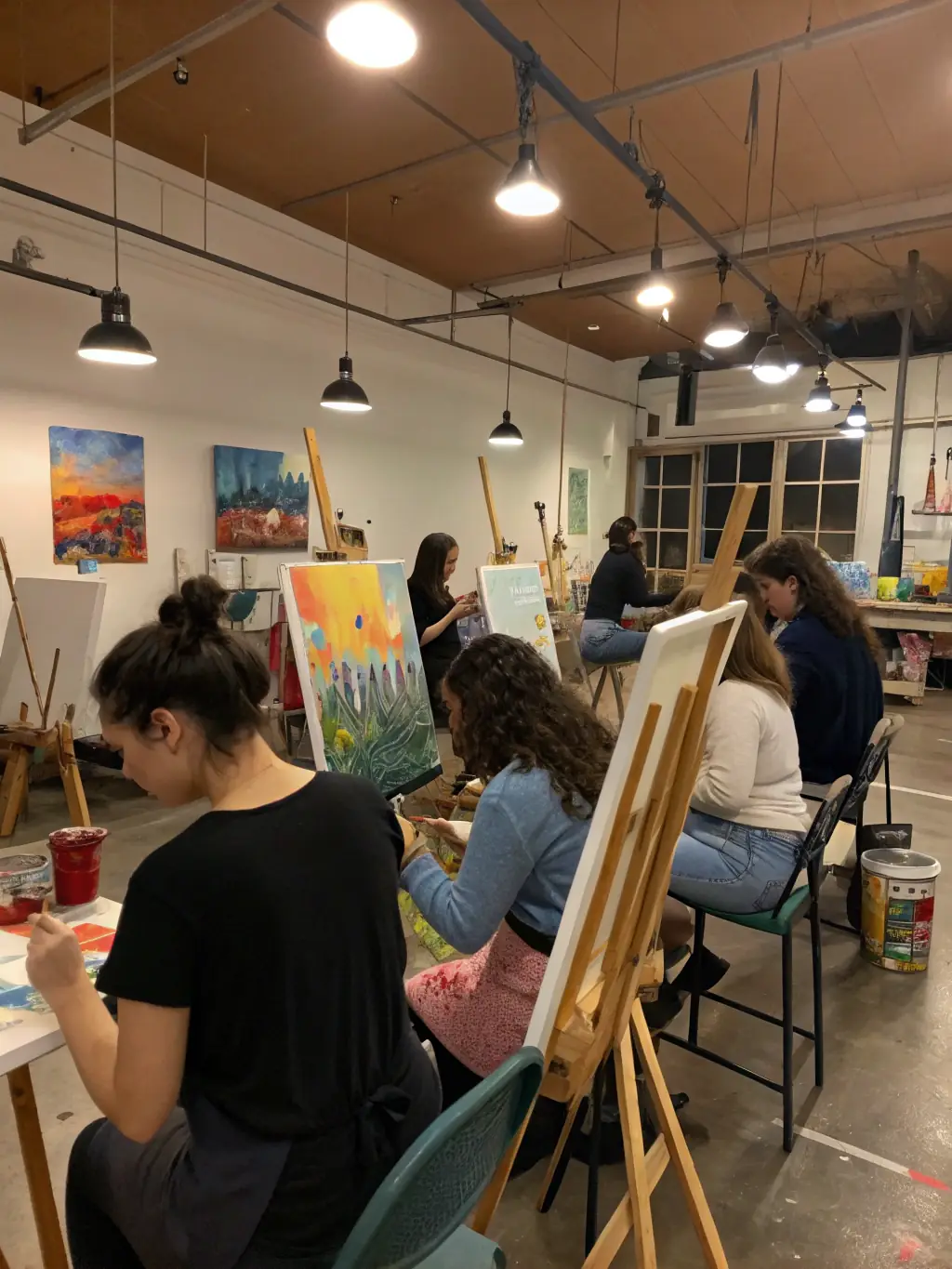 A dynamic image of a creative workshop at BOMBE ET MOQUETTE, featuring participants of various ages deeply engrossed in painting, sculpting, or mixed media projects, guided by an instructor.